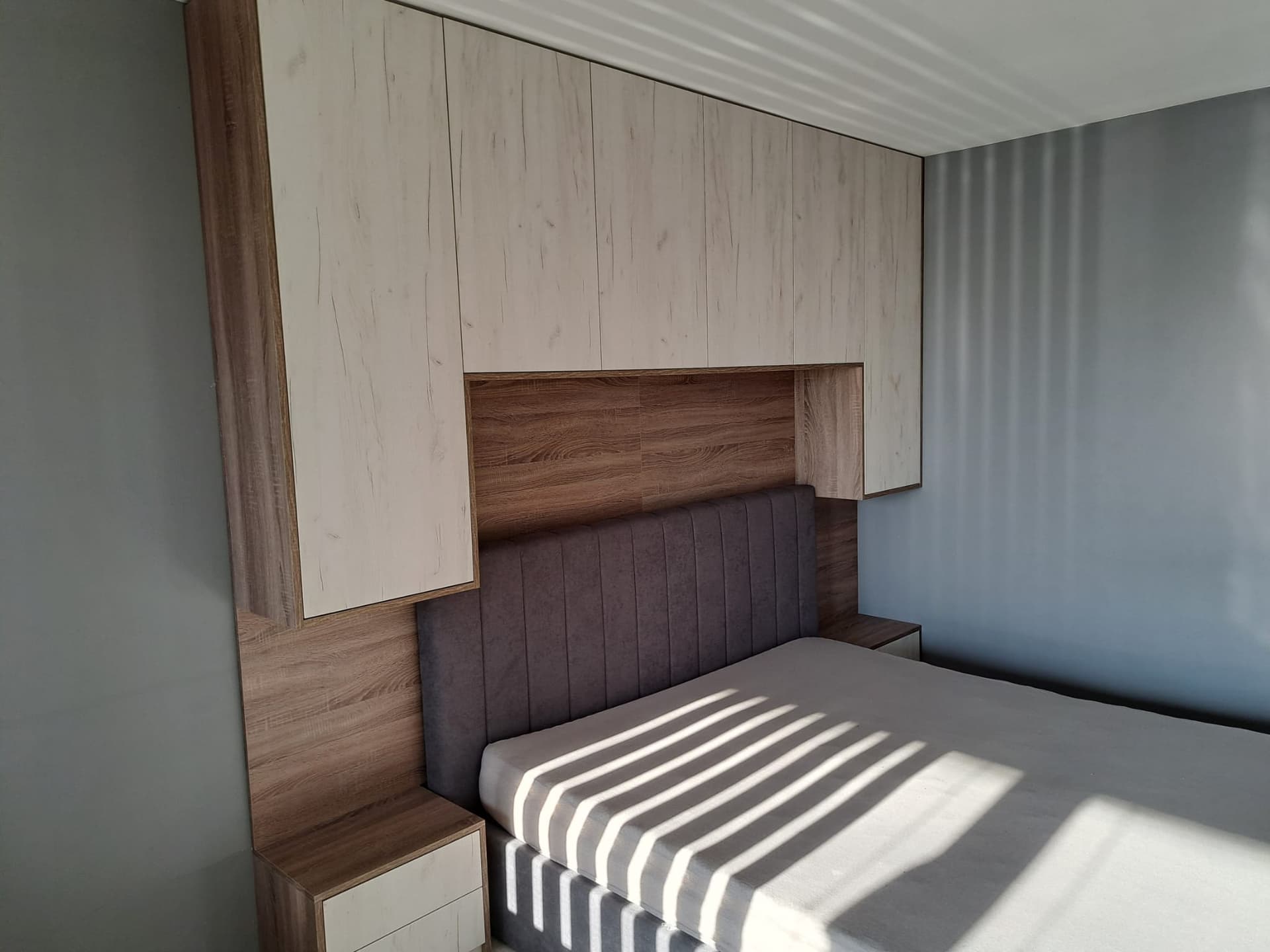 Skriňa s integrovaným čelom postele a nočnými stolíkmi